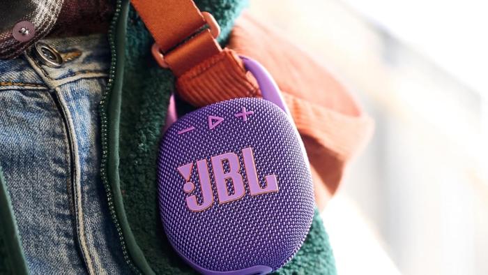JBL Clip 5 Bluetooth speaker attached to a bag strap.
