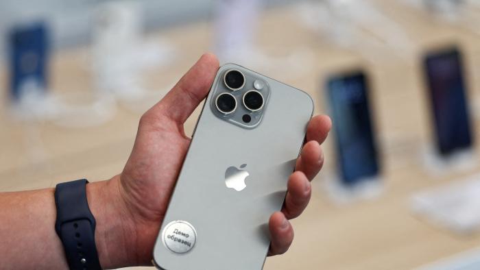 FILE PHOTO: A man holds an Apple iPhone 16 Pro Max ahead of the launch of sales of the new iPhone 16 series smartphones in a store in Moscow, Russia September 20, 2024. The sign on the sticker reads: "Demo model." REUTERS/Evgenia Novozhenina/File Photo